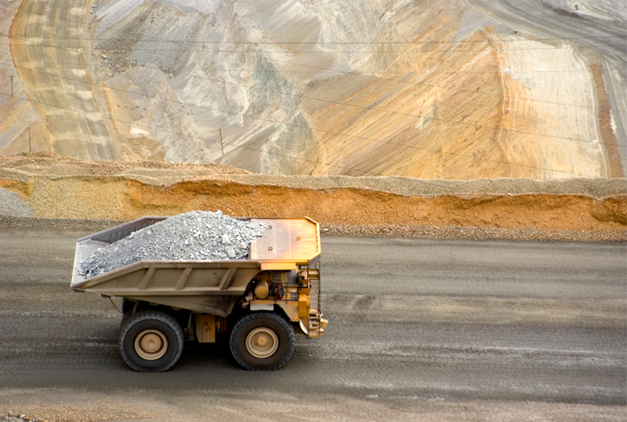 photo of a dump truck hauling gravel through a quarry