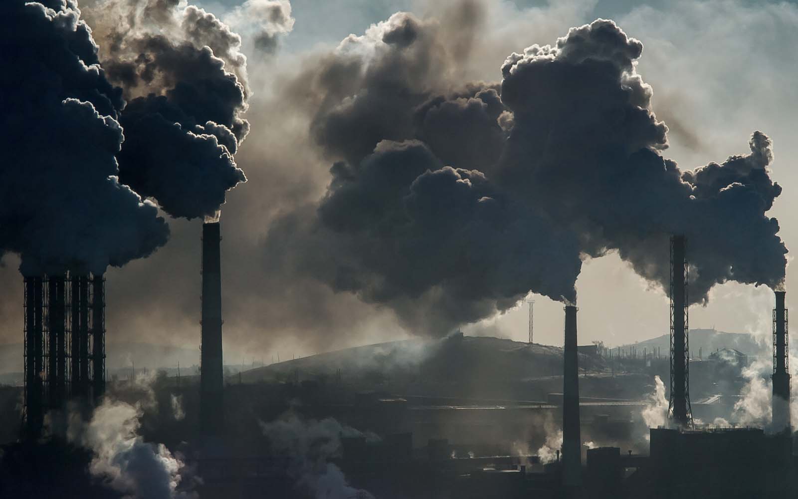 refinery with billowing smoke plumes