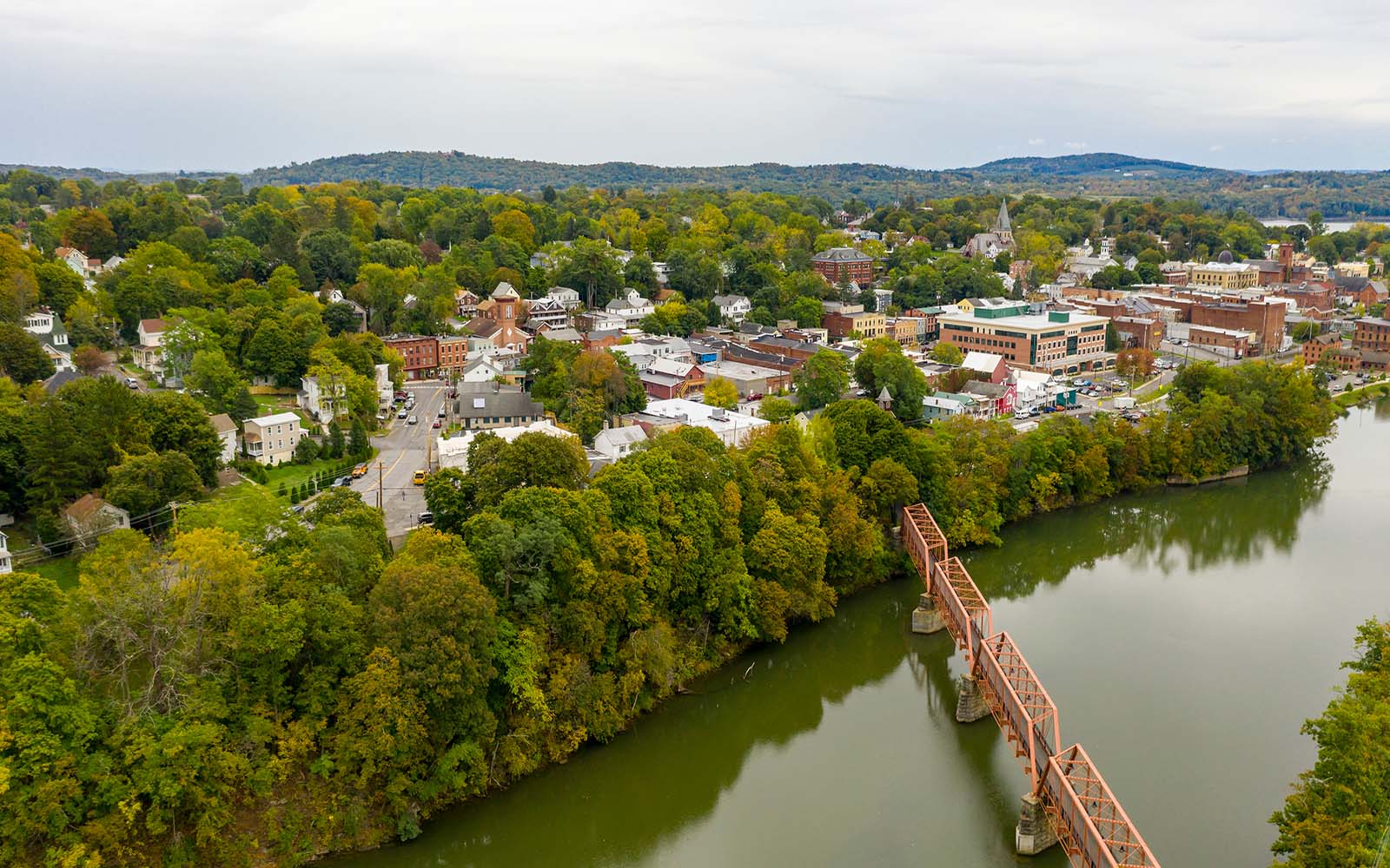 A New York State town alongside a river crossed by a bridge.