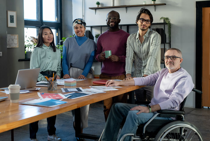 Photo of diversified team of people around a table in an office setting