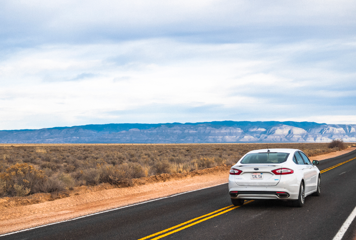 Photo of white car driving along a highway