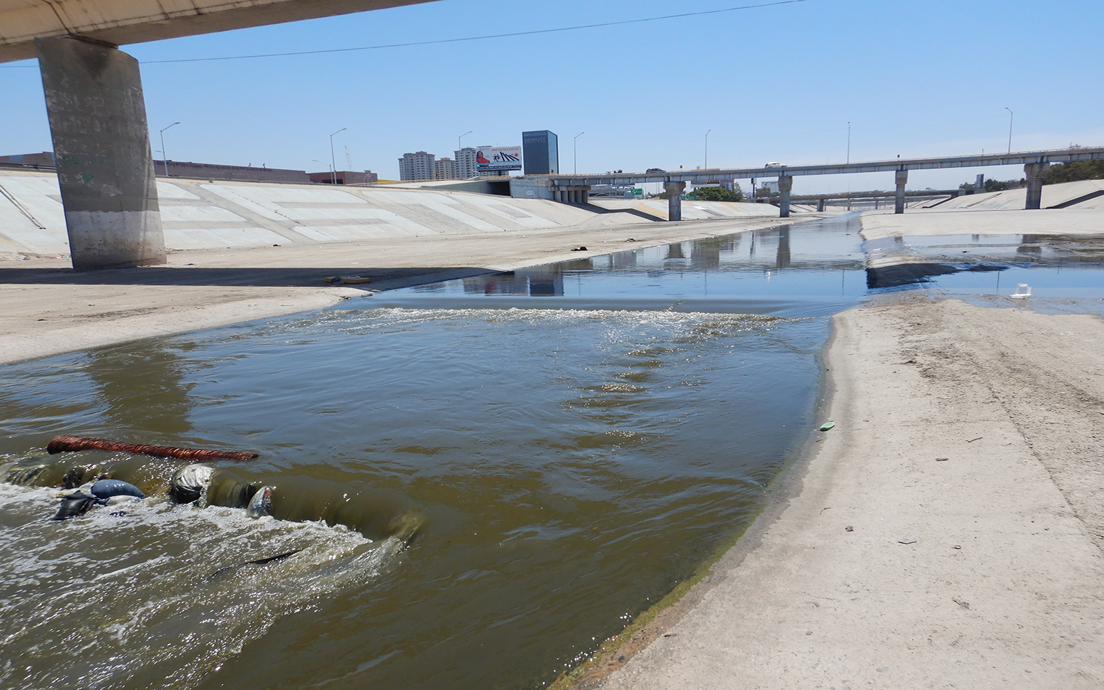 The Tijuana river flowing under a series of bridges and roadways.