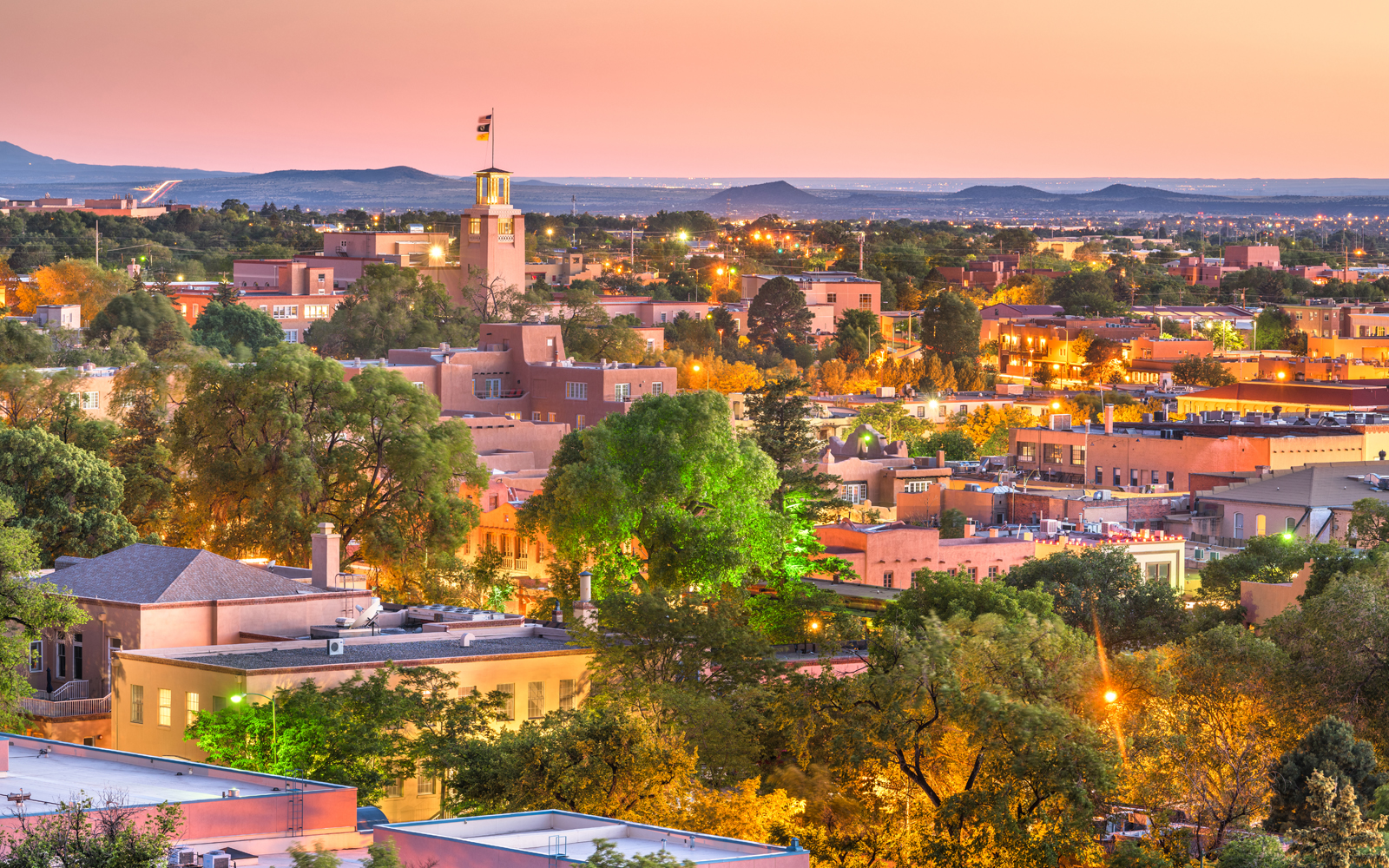 New Mexico skyline at dusk with the mountains behind it.