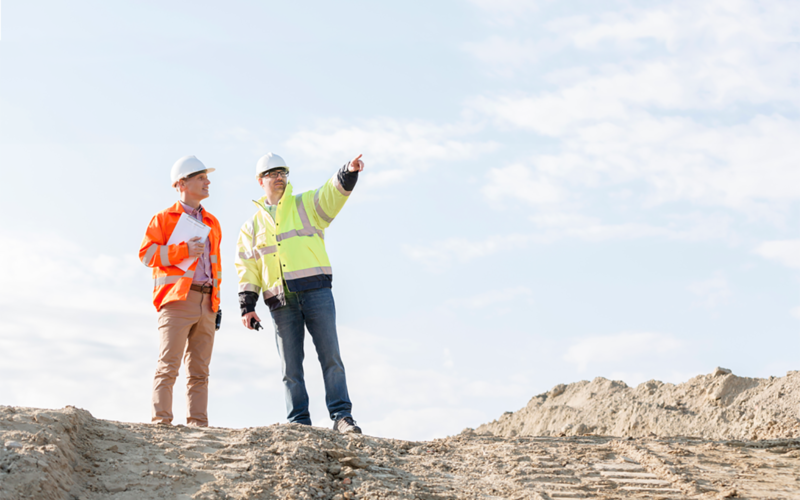 Photo of 2 construction Inspectors. One is pointing into the distance