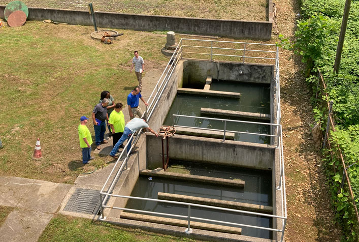 Photo shows an ariel view of people observing small wastewater and drinking water system