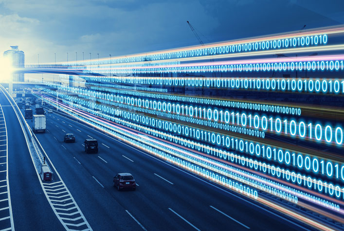 Photo of cars on a highway with a graphic of numbers running along-side which is vehicle trip data—known as “telematics”