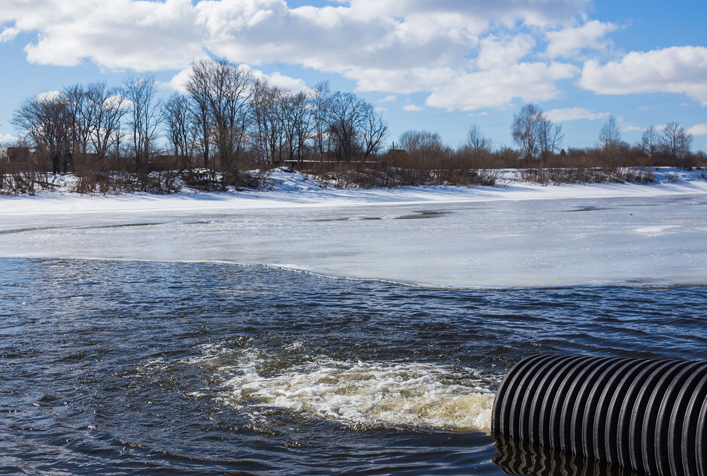 Photo of river with water discharging into it.