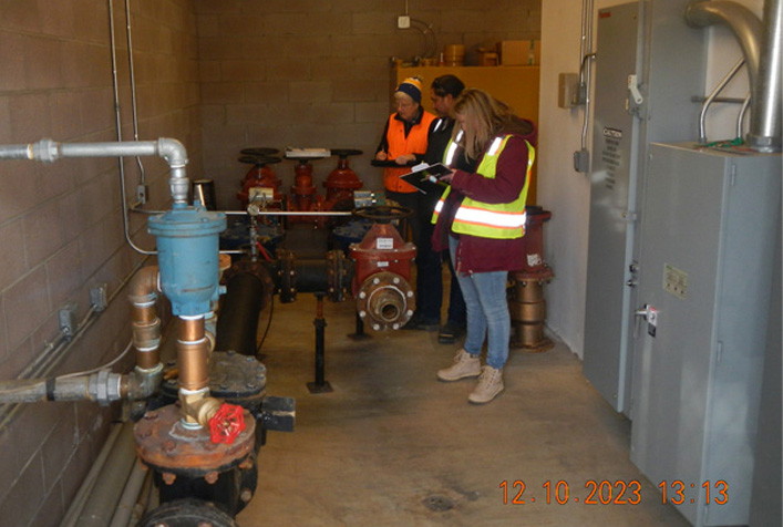 photo of person taking notes next to water pipe infrustructure system