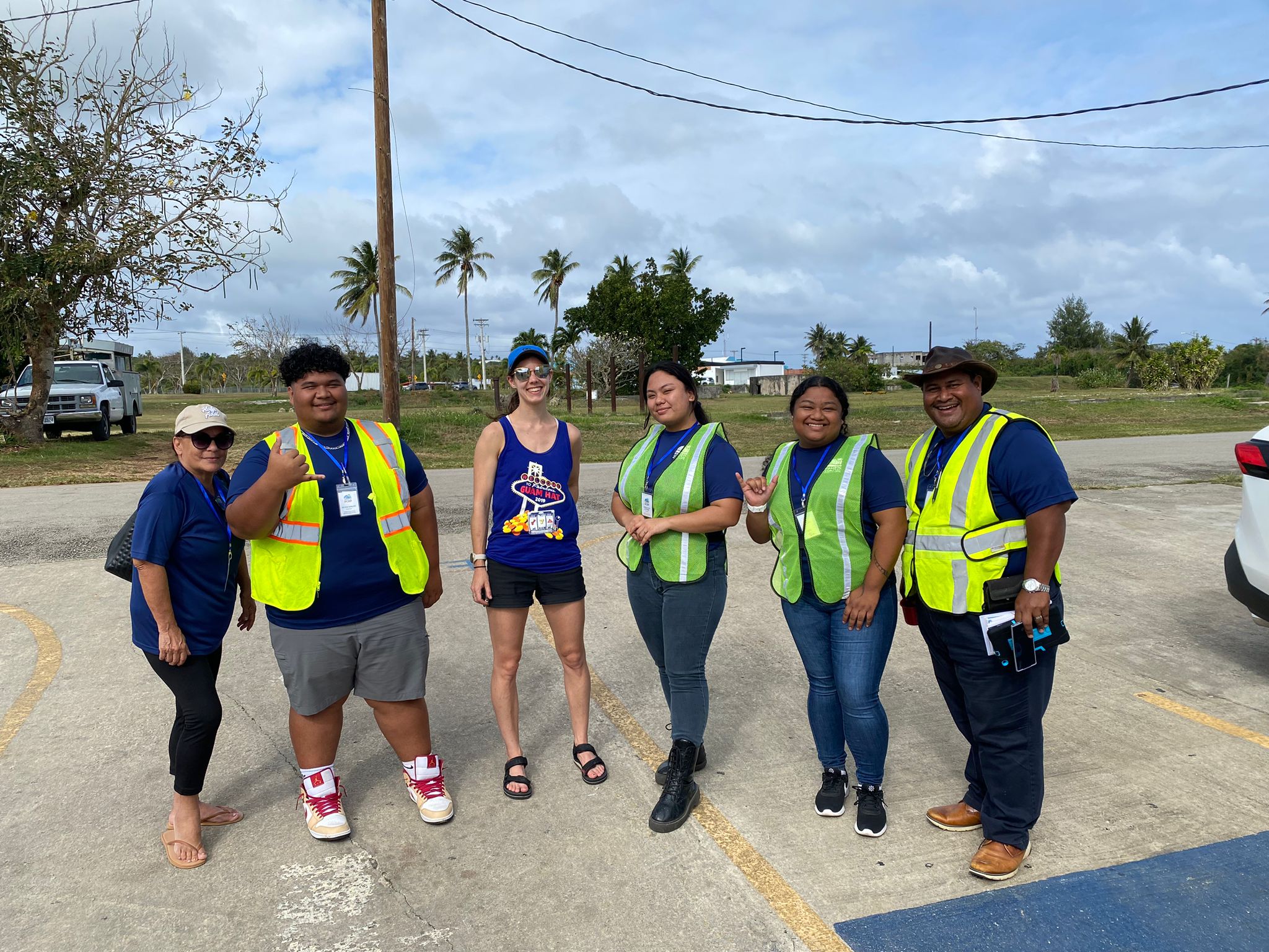 A team of individuals in safety vests stands in a parking lot, possibly involved in a safety inspection or event management.