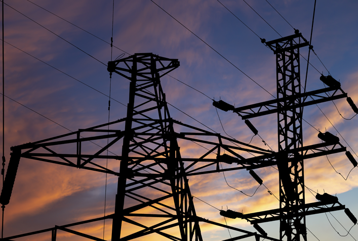 High voltage power line, black contour, against the background of an evening sky.