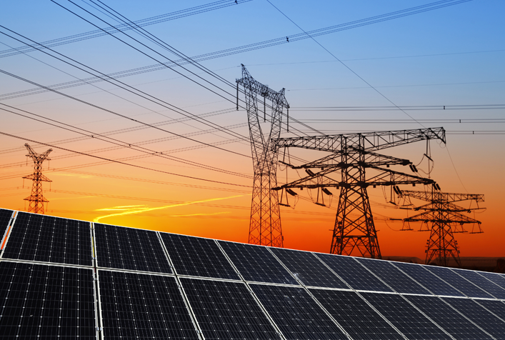 photo of solar panels and beyond that are power lines with a golden sunset in the background