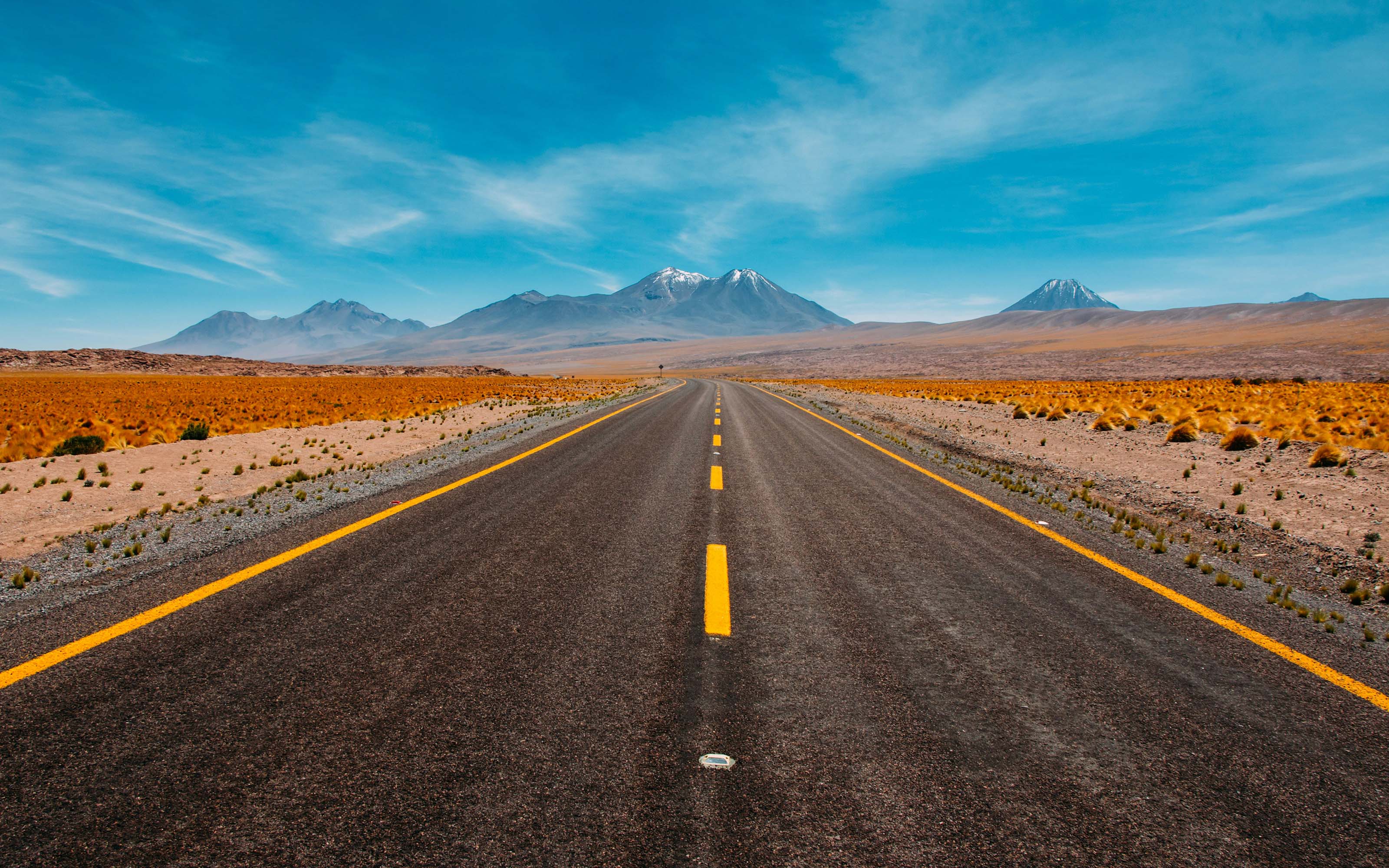 An image of a road with mountains in the distance