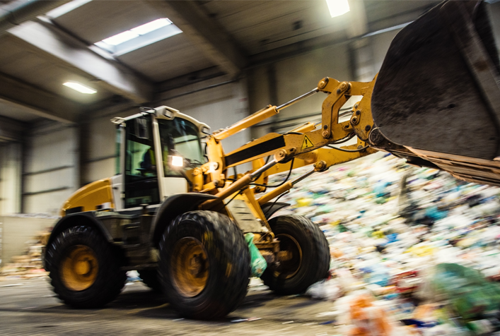 Photo of a front-end loader moving trash waste