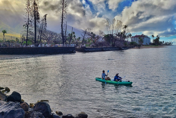 photo of 2 people kayaking and collecting sediment, sand, and water quality samples along the shoreline