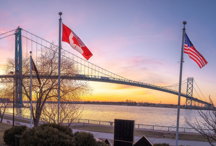 Photo of Great Lakes Basin viewing a bridge with both an American flag and Canadian flag in the forefront
